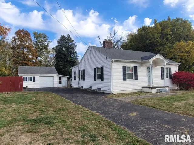 a view of a yard in front of a house with large trees