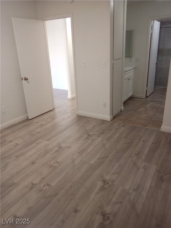 4830 Nara Vista Way, Unit 103 Las Vegas, NV 89103 - Photo 12 of 20 Unfurnished bedroom featuring light wood finished floors and connected bathroom