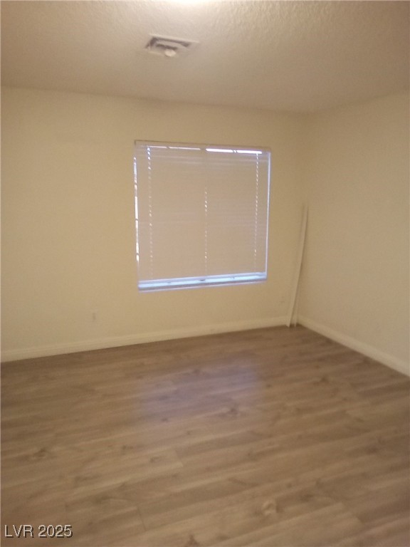 4830 Nara Vista Way, Unit 103 Las Vegas, NV 89103 - Photo 7 of 20 Spare room with wood finished floors and a textured ceiling