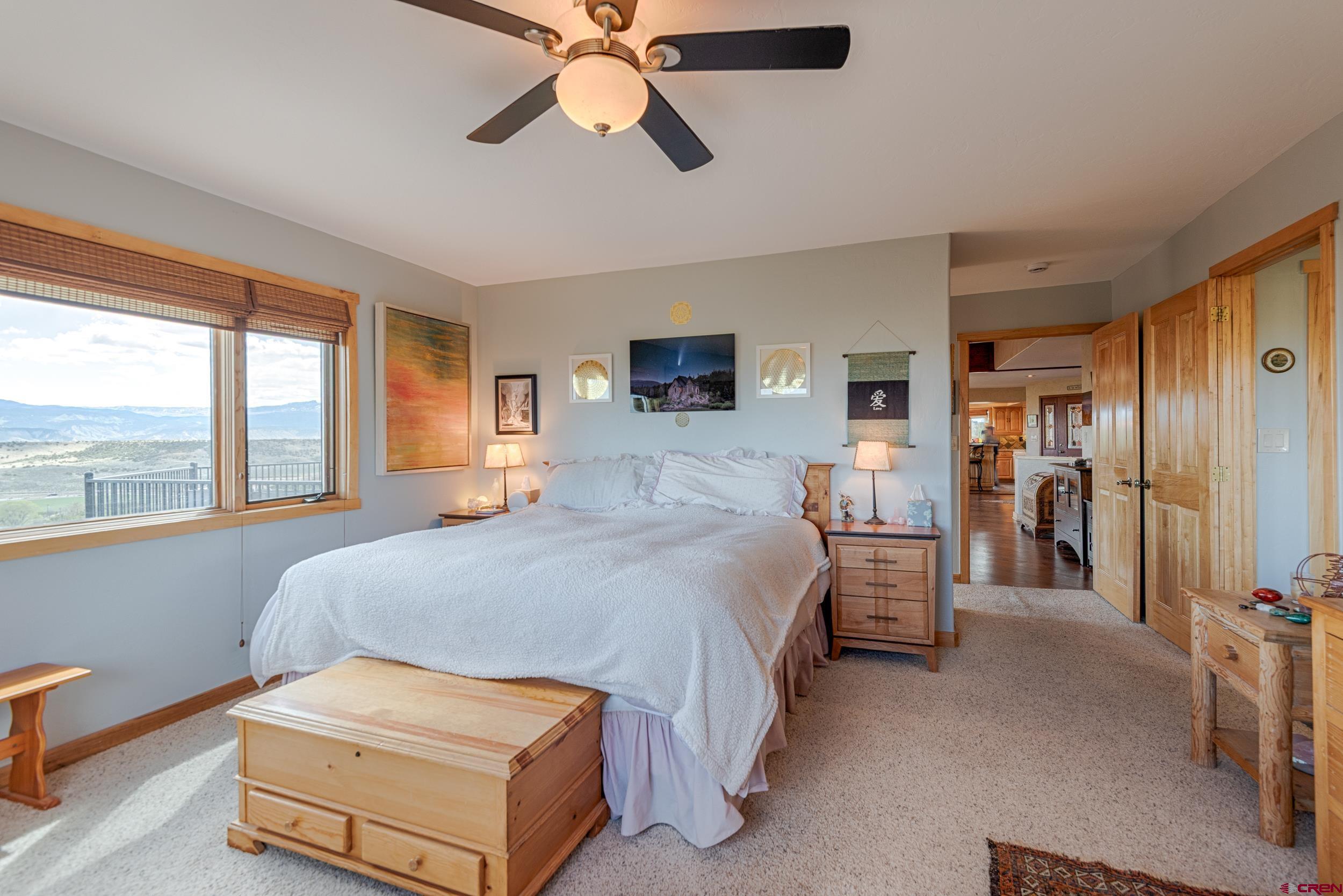 20891 Solitude Road Montrose, CO 81403 - Photo 16 of 39 a bedroom with a bed and a chandelier