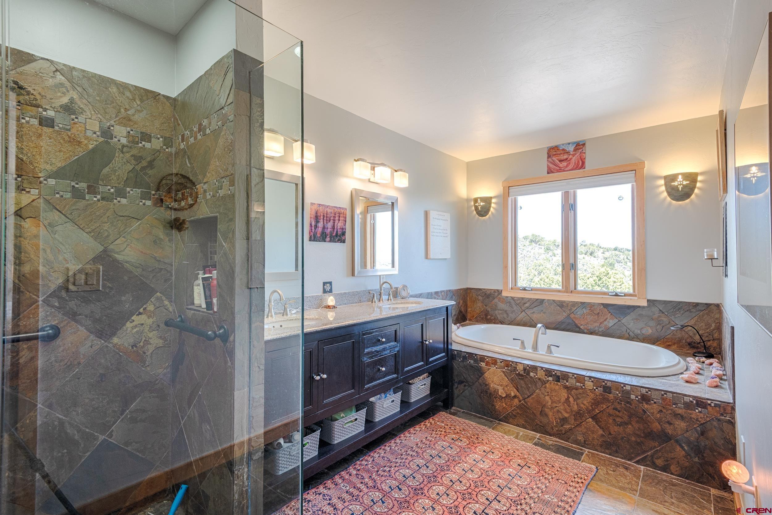 20891 Solitude Road Montrose, CO 81403 - Photo 18 of 39 a spacious bathroom with a tub sink shower and mirror