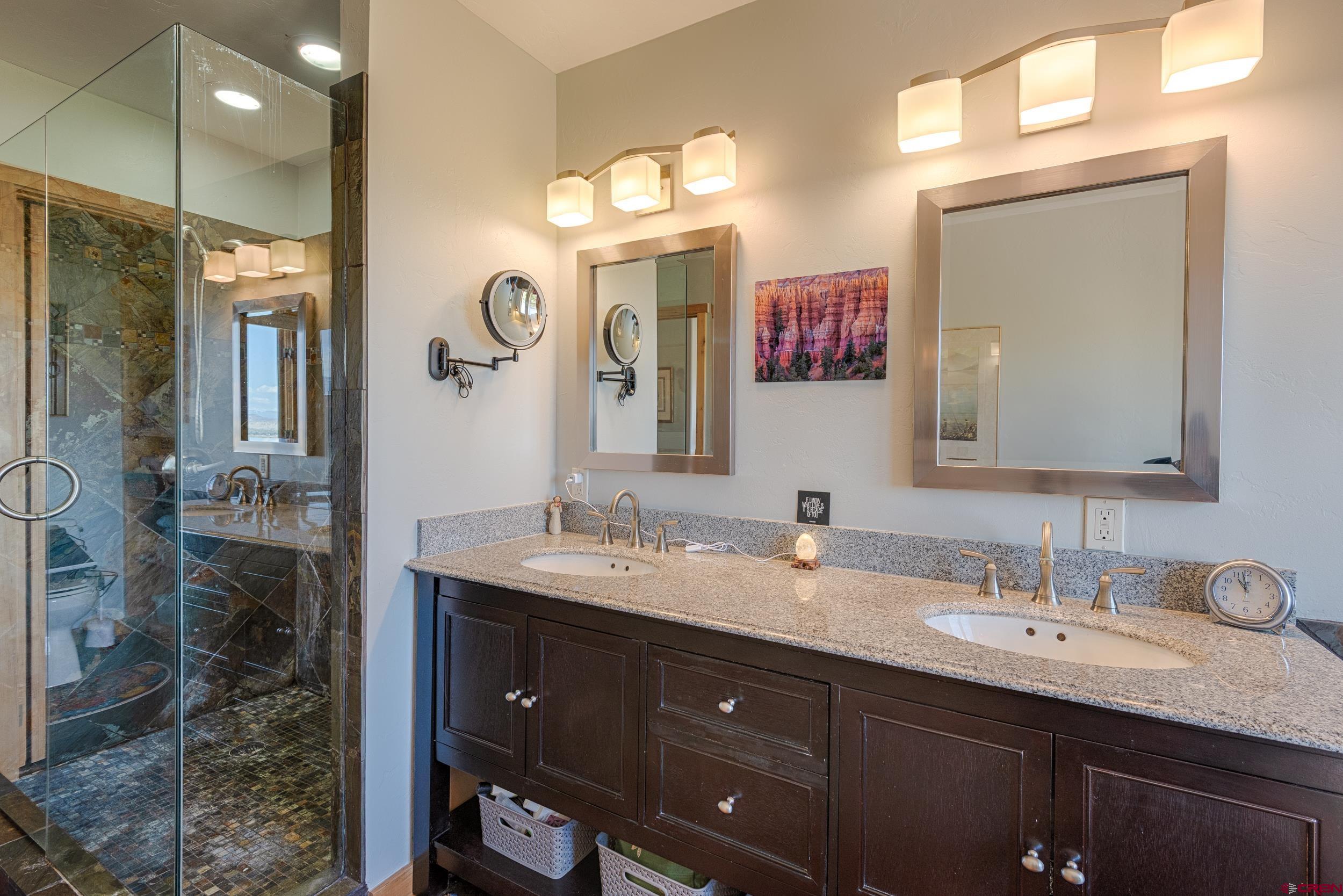 20891 Solitude Road Montrose, CO 81403 - Photo 19 of 39 a bathroom with a double vanity sink and a mirror