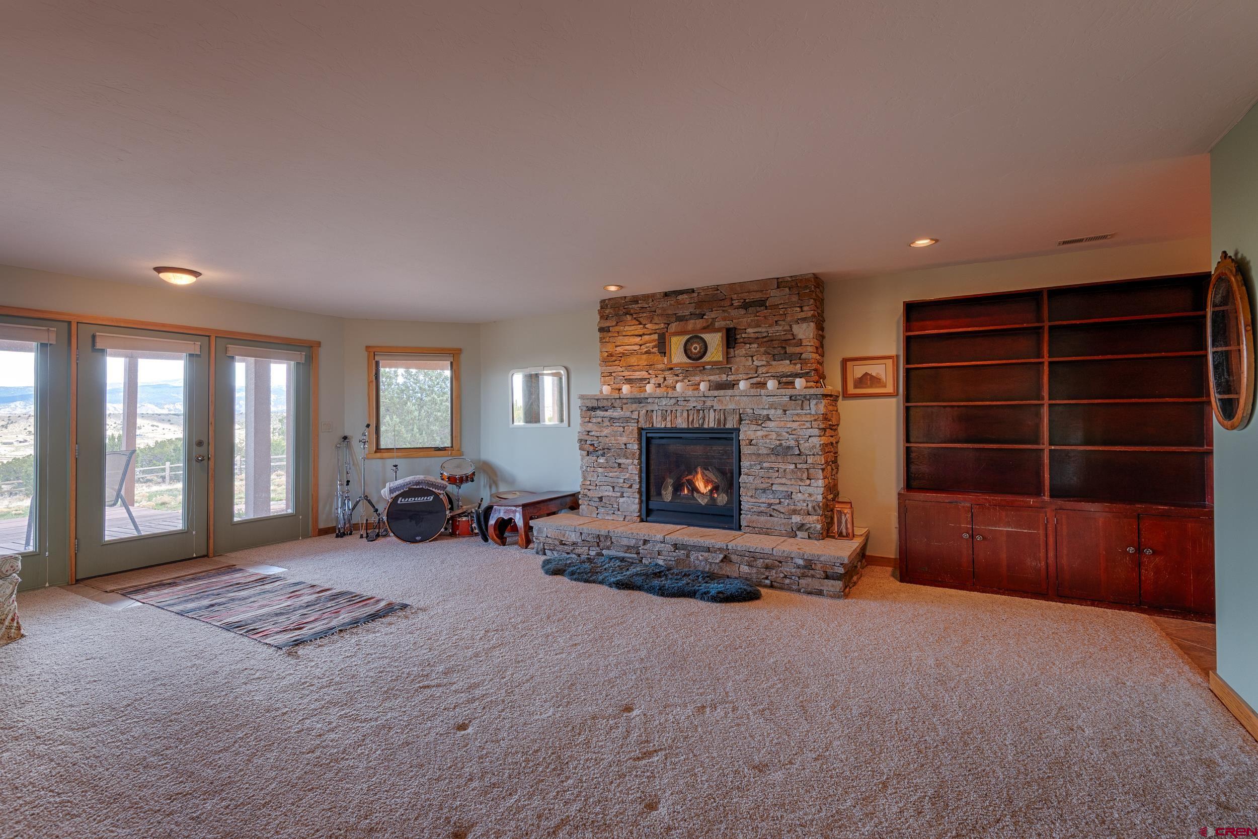 20891 Solitude Road Montrose, CO 81403 - Photo 24 of 39 a living room with furniture and a fireplace