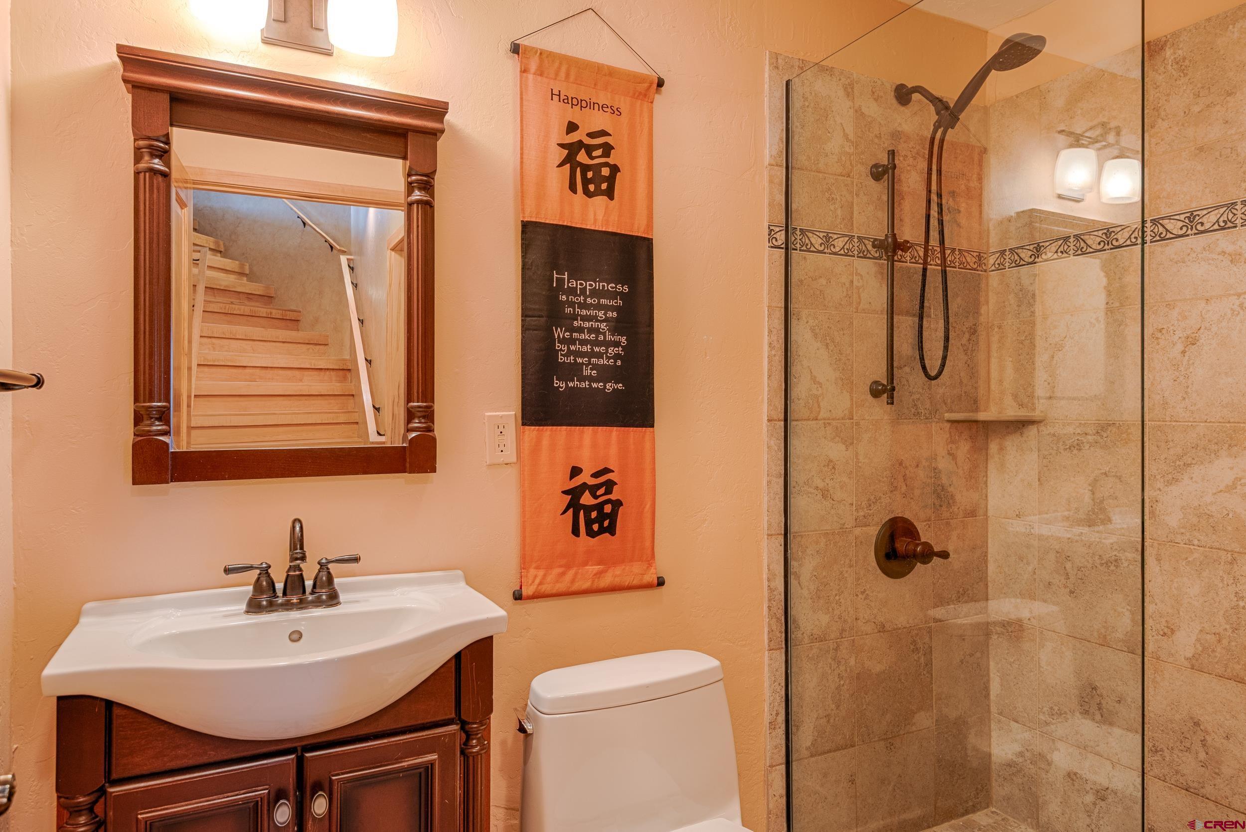 20891 Solitude Road Montrose, CO 81403 - Photo 27 of 39 a bathroom with a sink a mirror and a shower