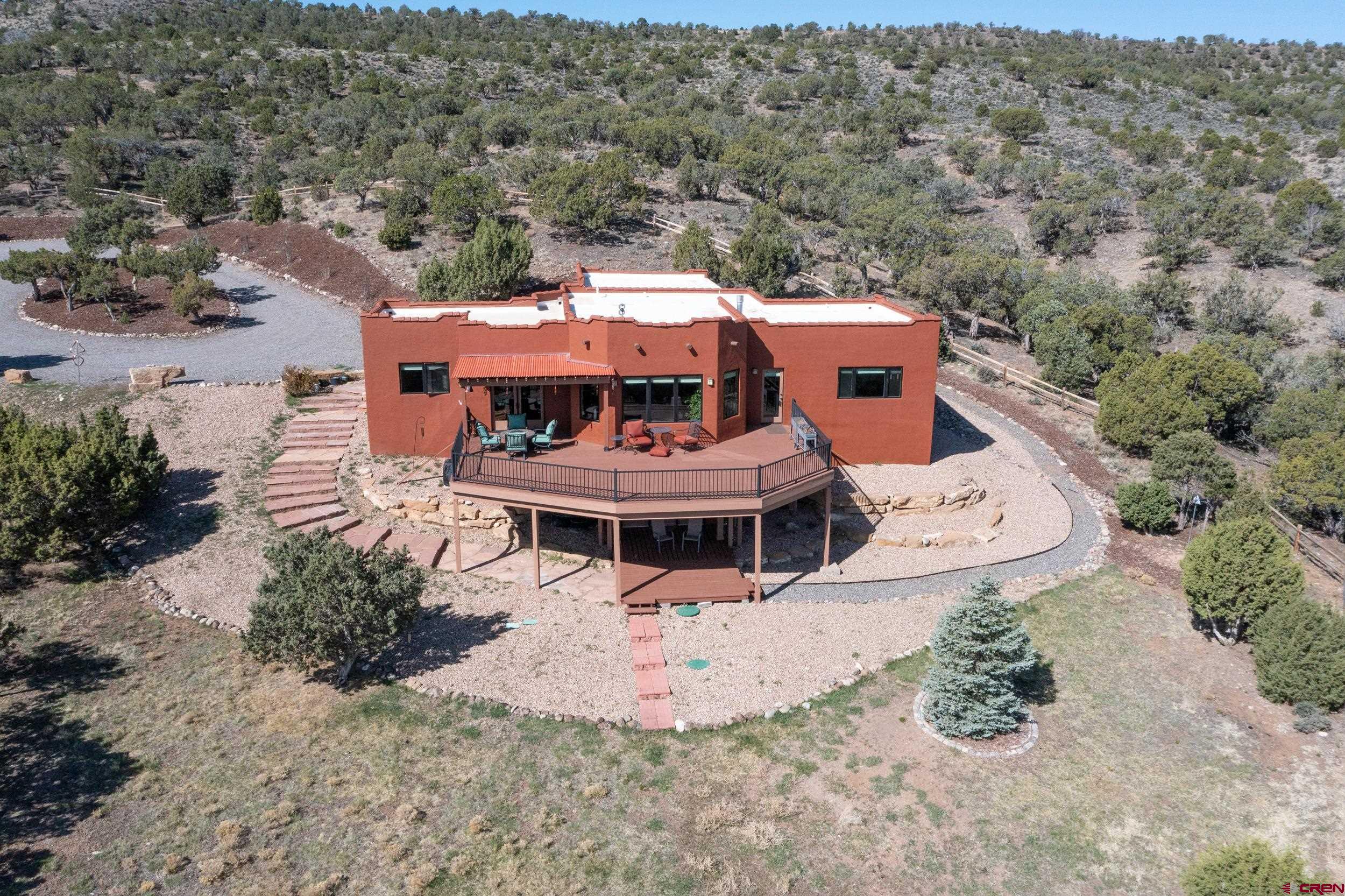 20891 Solitude Road Montrose, CO 81403 - Photo 30 of 39 an aerial view of a house with large trees and lawn chairs