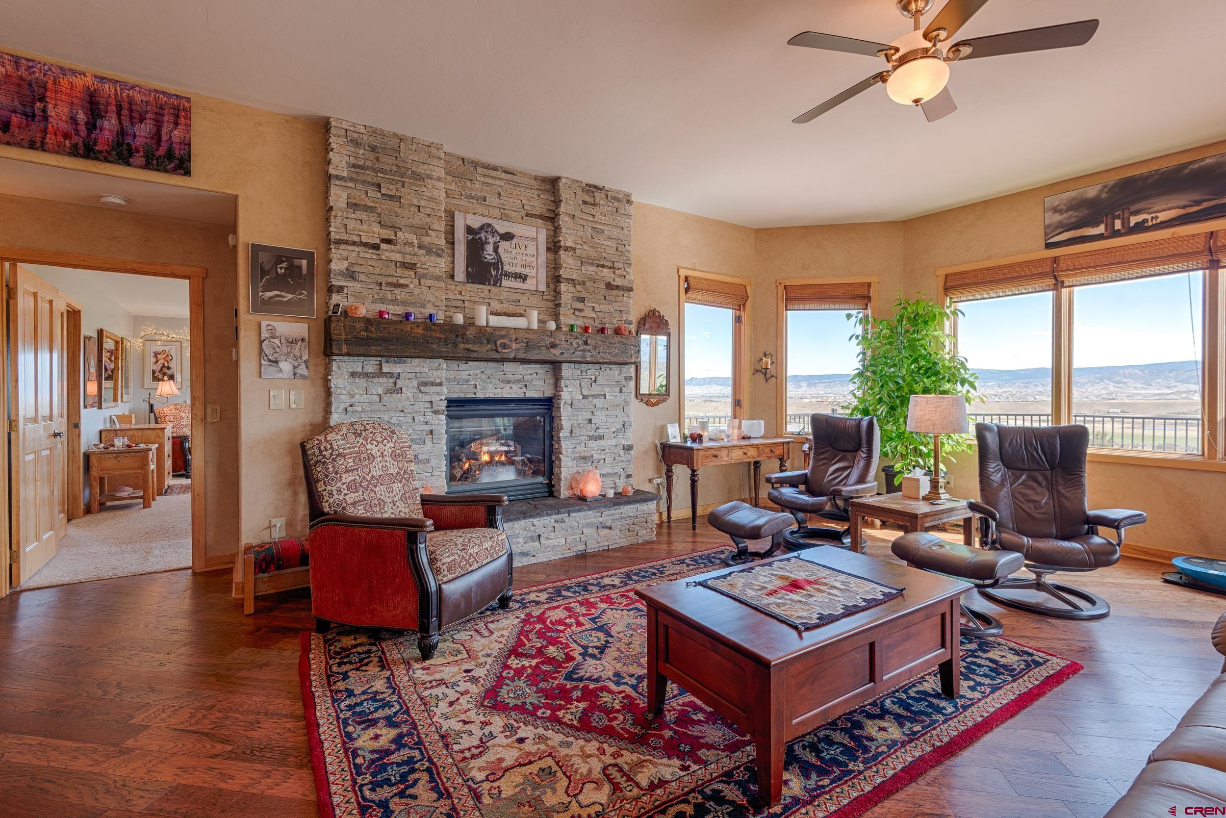 20891 Solitude Road Montrose, CO 81403 - Photo 5 of 39 a living room with furniture a fireplace and a table
