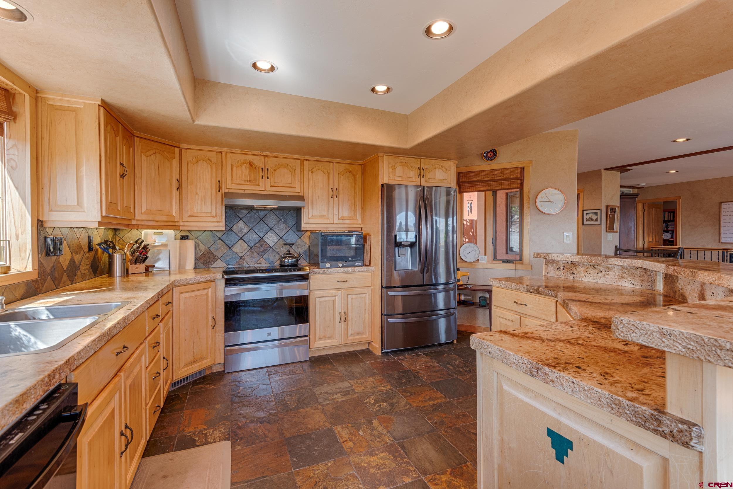 20891 Solitude Road Montrose, CO 81403 - Photo 9 of 39 a large kitchen with a stove a sink and a refrigerator