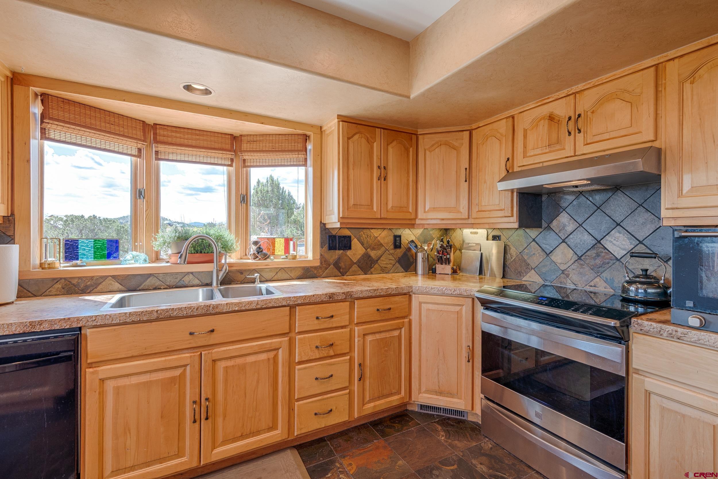 20891 Solitude Road Montrose, CO 81403 - Photo 10 of 39 a kitchen with granite countertop white cabinets and white appliances