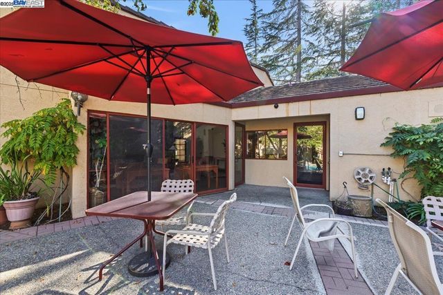 a patio with a table and chairs under an umbrella
