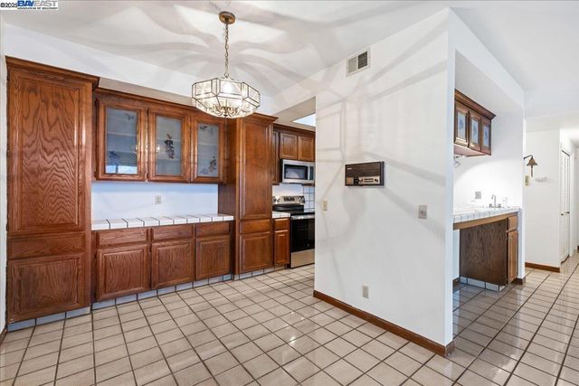 a kitchen with stainless steel appliances granite countertop a refrigerator a oven a sink dishwasher and a stove with wooden floor