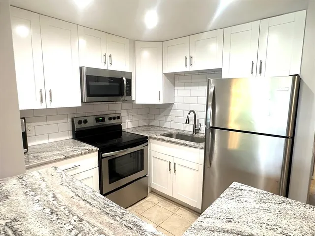 a kitchen with a refrigerator sink and microwave