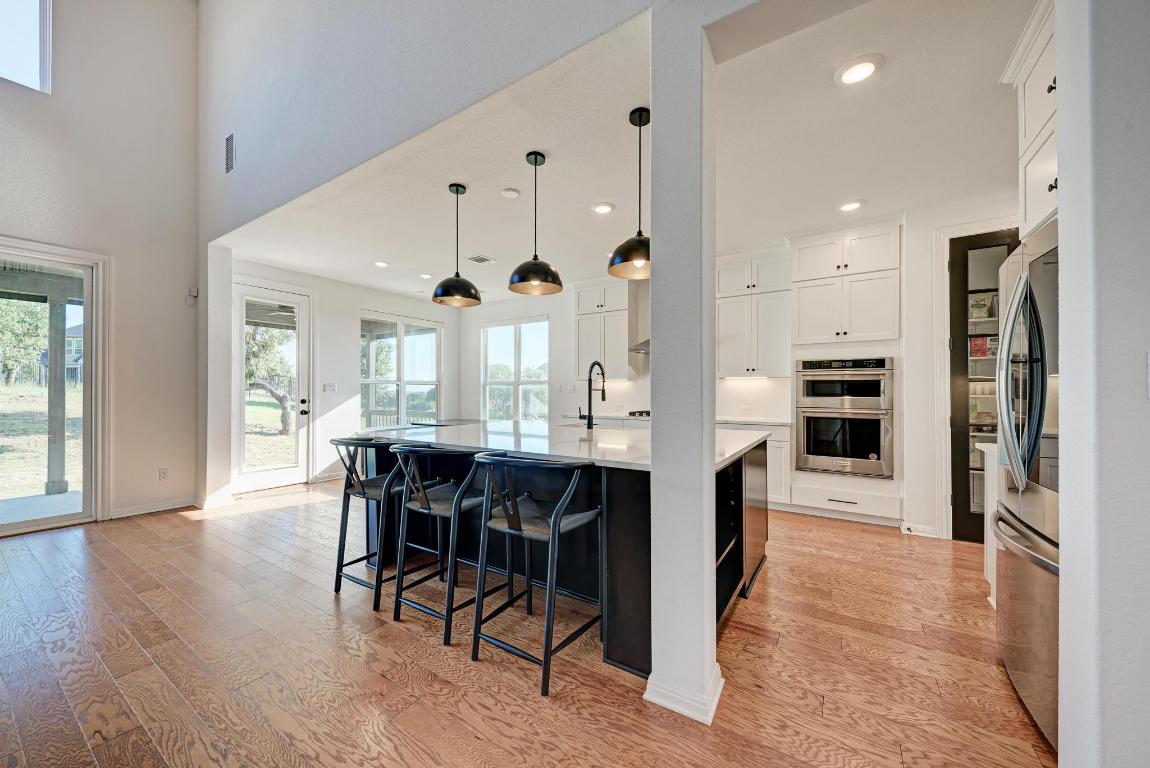 156 Verdejo Drive Dripping Springs, TX 78620 - Photo 13 of 38 a large kitchen with a table and chairs