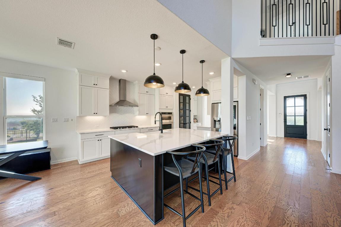 156 Verdejo Drive Dripping Springs, TX 78620 - Photo 14 of 38 a kitchen with stainless steel appliances kitchen island a chandelier