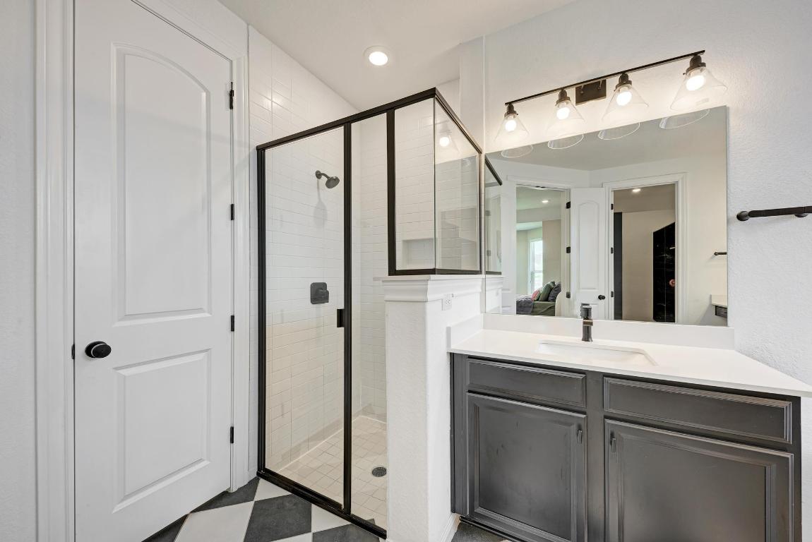 156 Verdejo Drive Dripping Springs, TX 78620 - Photo 23 of 38 a bathroom with a shower sink and mirror