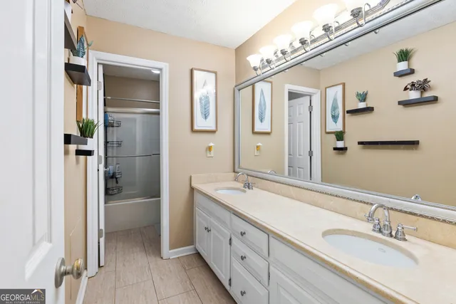 a spacious bathroom with a granite countertop sink mirror and shower