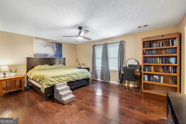 a bedroom with a large bed and a bookshelf