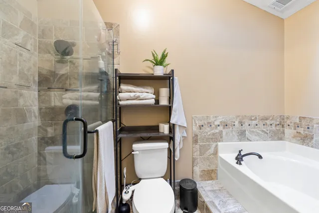 a bathroom with a toilet and a shower