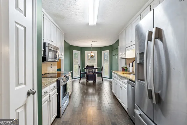 a kitchen with stainless steel appliances a refrigerator and a stove top oven