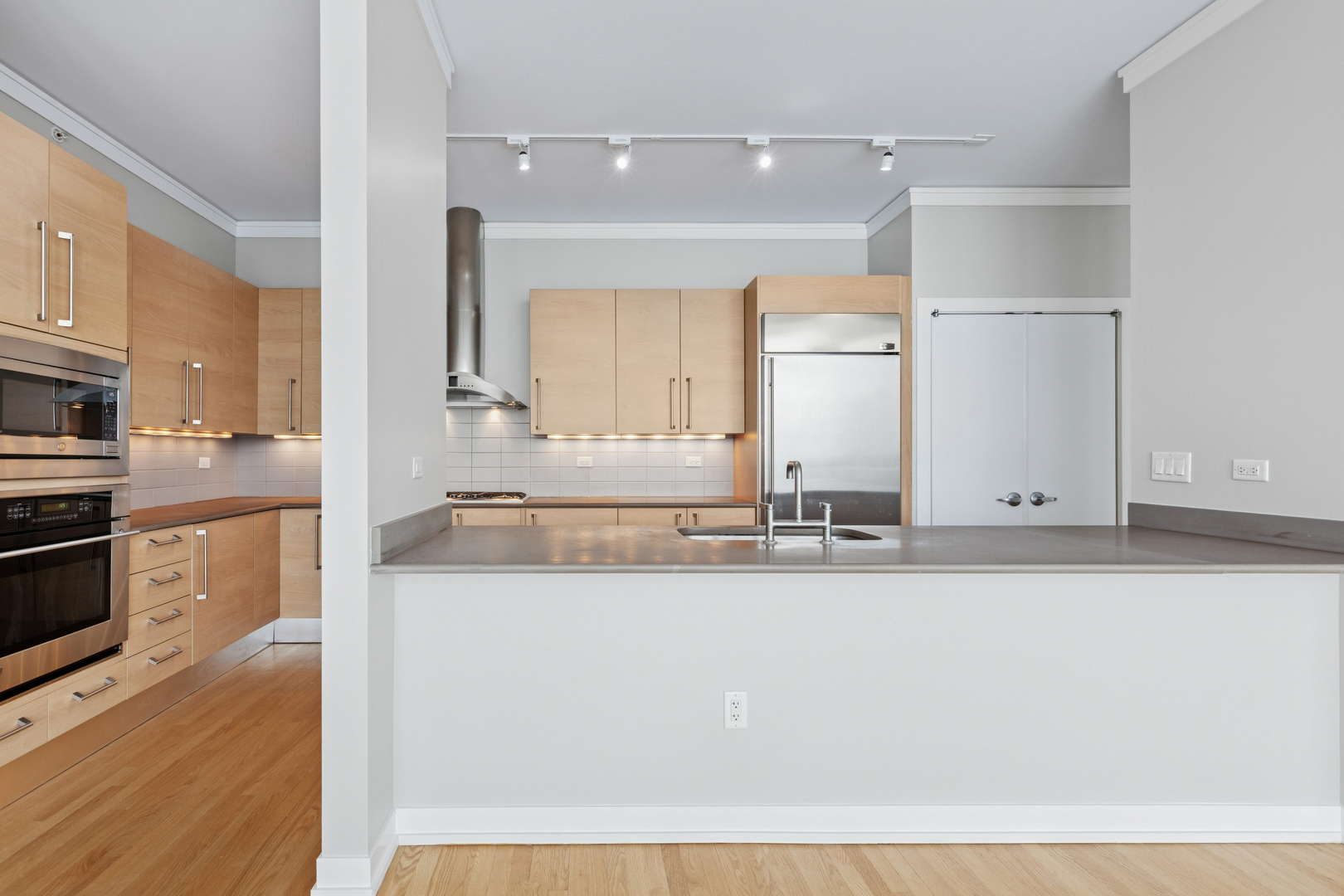1570 Elmwood Avenue, Unit 1504 Evanston, IL 60201 - Photo 10 of 24 a large white kitchen with kitchen island white cabinets and stainless steel appliances
