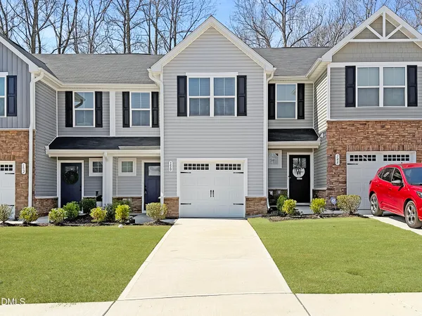 a front view of a house with a yard and garage