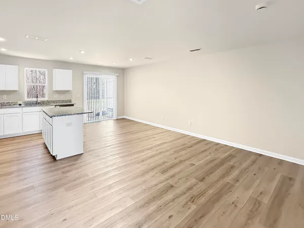 a large kitchen with wooden floors and stainless steel appliances