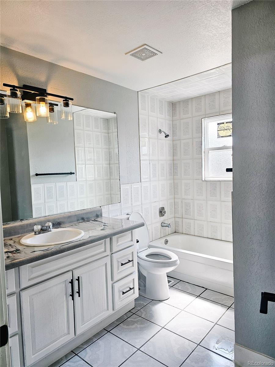 4716 Freeport Way Denver, CO 80239 - Photo 17 of 29 a bathroom with a double vanity sink a toilet a mirror and shower