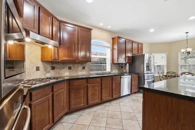 a large kitchen with stainless steel appliances and cabinets