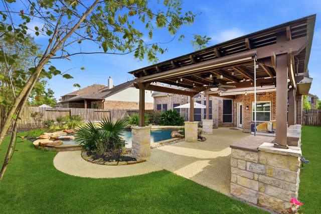 a patio with a table and chairs and potted plants