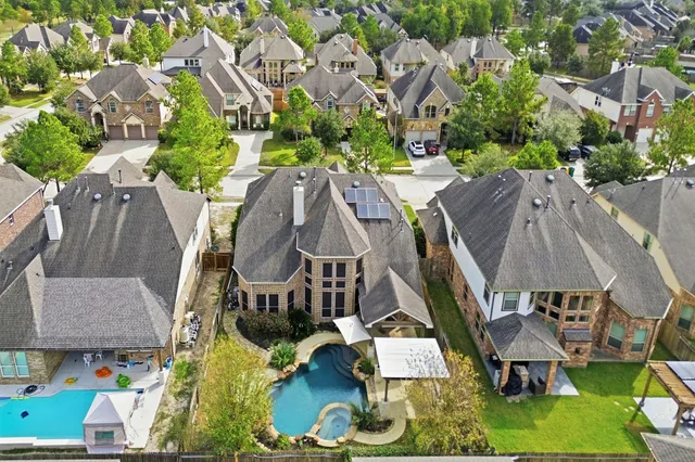 an aerial view of a house with swimming pool and outdoor seating