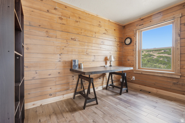 20 Q Puma Road Fairview, UT 84629 - Photo 9 of 27 Wood-paneled room featuring wood-finish flooring, a large window with wood trim, and a built-in dark wood shelving unit