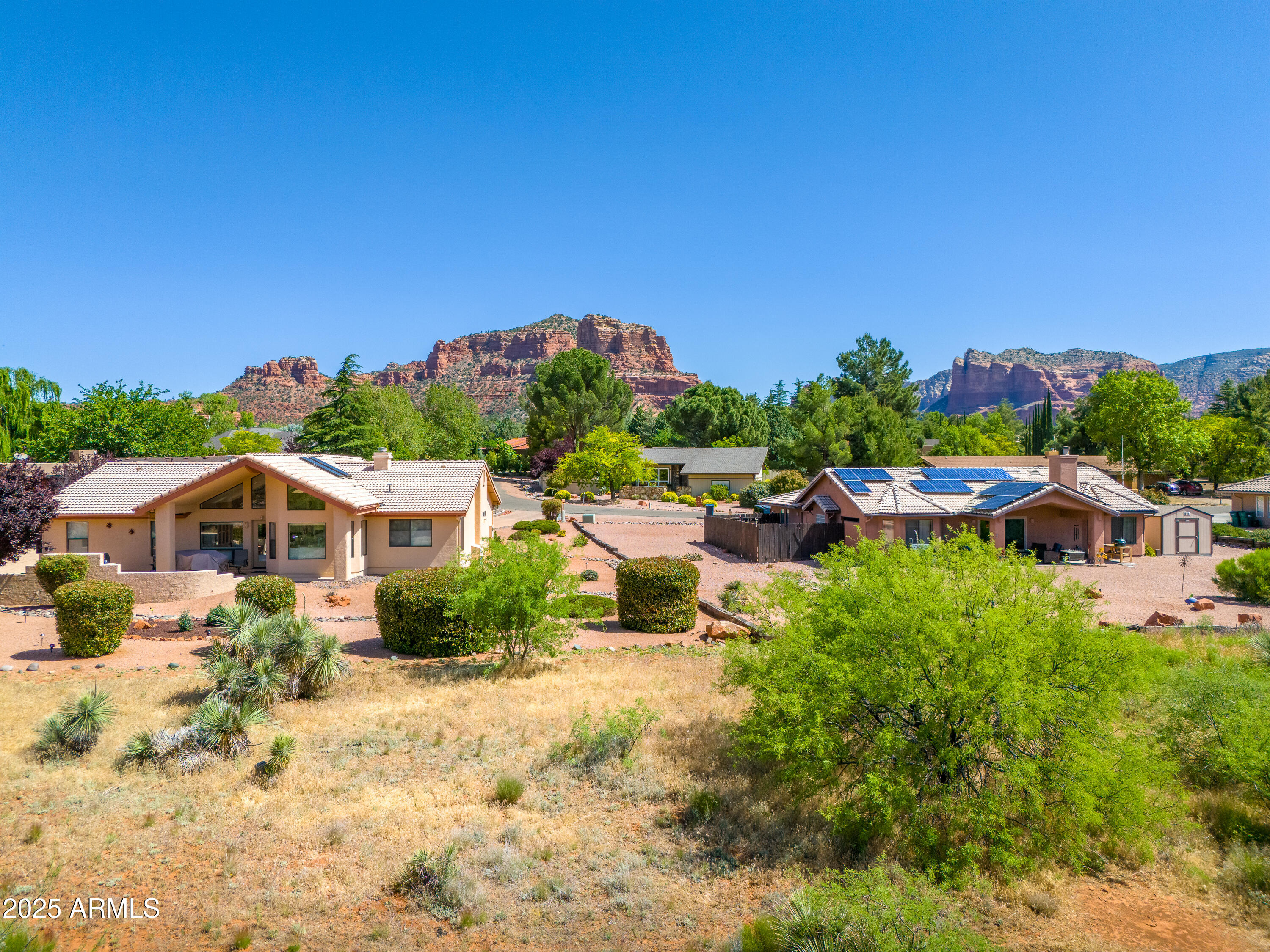 105 East Saddlehorn Road, Unit 161 Sedona, AZ 86351 - Photo 17 of 33 a view of a house with a yard and table and chairs under an umbrella