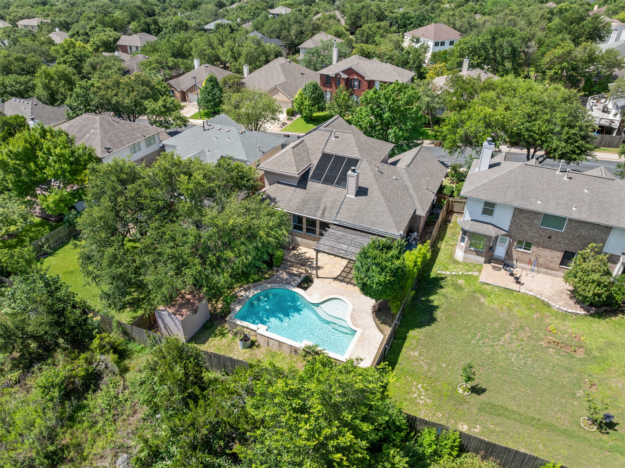 8820 Colberg Drive Austin, TX 78749 - Photo 32 of 35 An aerial perspective reveals a vibrant neighborhood with a home boasting a private pool, an inviting patio, and lush greenbelt surroundings.