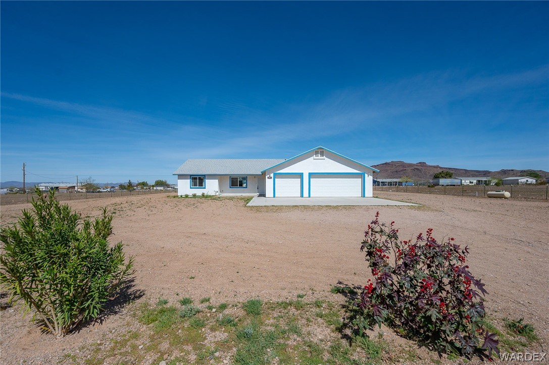 3411 West Carmichael Road Golden Valley, AZ 86413 - Photo 63 of 97 Ranch-style home featuring driveway, an attached garage, a mountain view, and stucco siding