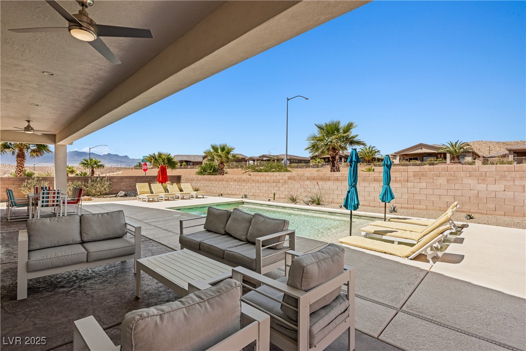 1357 Manassas Ridge Mesquite, NV 89027 - Photo 43 of 72 Fenced backyard with ceiling fan, outdoor lounge area, a patio, and a mountain view