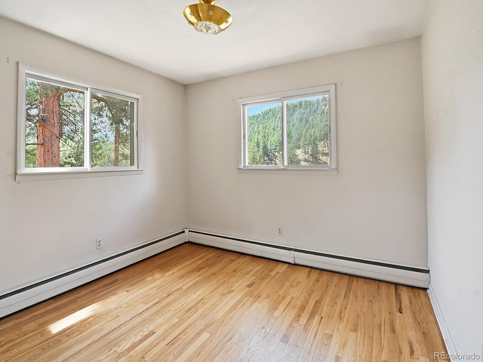 2830 Kerr Gulch Road Evergreen, CO 80439 - Photo 26 of 48 a view of an empty room with wooden floor and a window