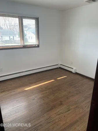 a view of a room with wooden floor and a window