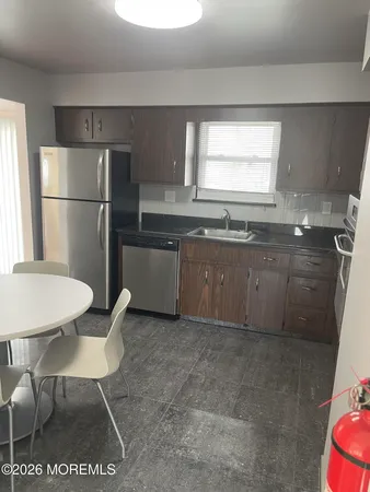 a kitchen with stainless steel appliances granite countertop a sink counter space and a refrigerator