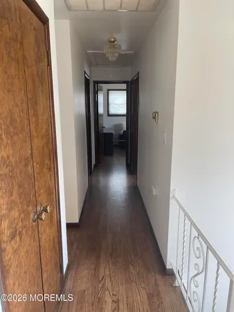a view of a hallway with wooden floor and stairs