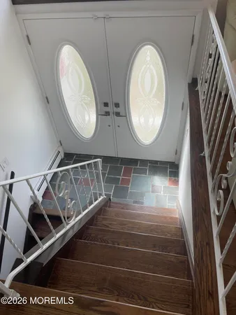 a view of a hallway with wooden floor and white walls