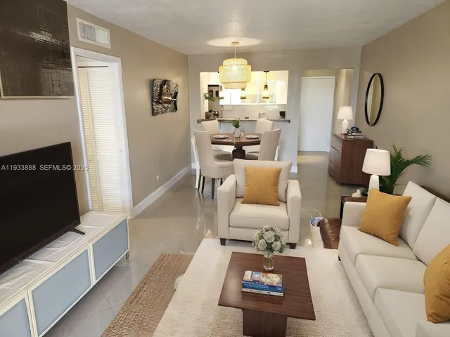 a living room with furniture a rug and a flat screen tv