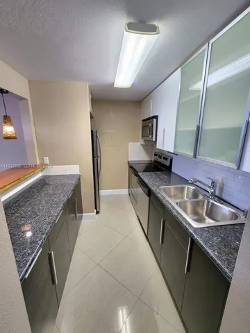 a kitchen with granite countertop a sink and a stove