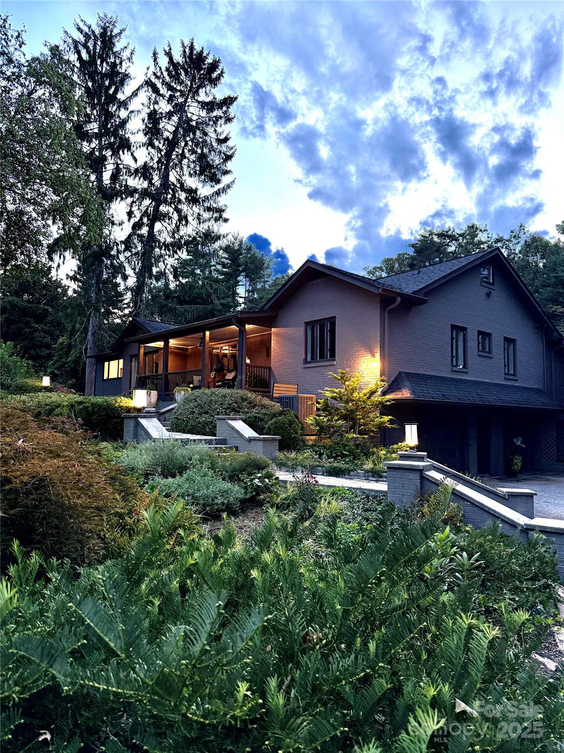 a view of a house with a big yard plants and large trees