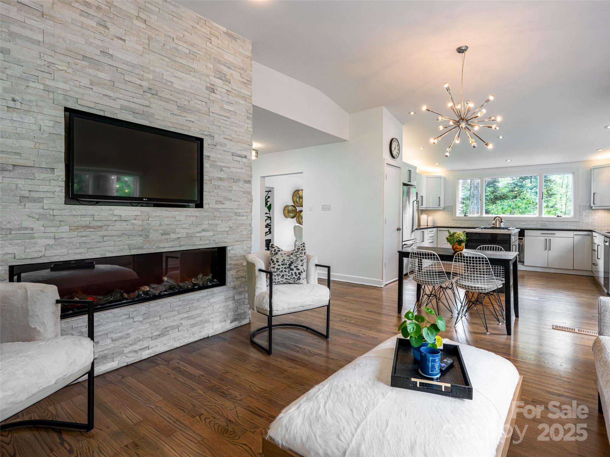 5 Busbee Road Asheville, NC 28803 - Photo 24 of 48 a living room with furniture a flat screen tv and a fireplace