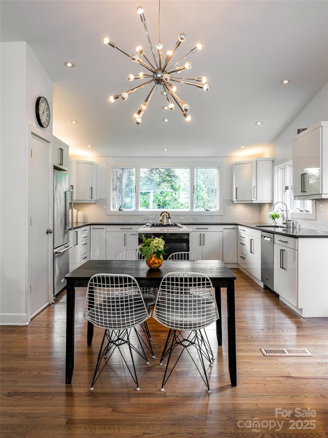5 Busbee Road Asheville, NC 28803 - Photo 10 of 48 a kitchen with stainless steel appliances a dining table chairs and wooden floor