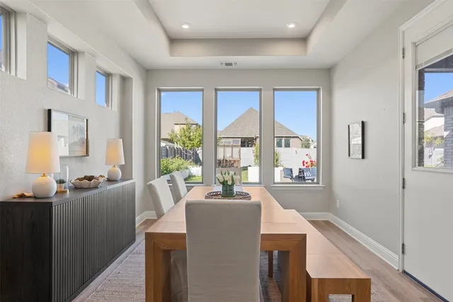 a view of a dining room with furniture a chandelier and wooden floor