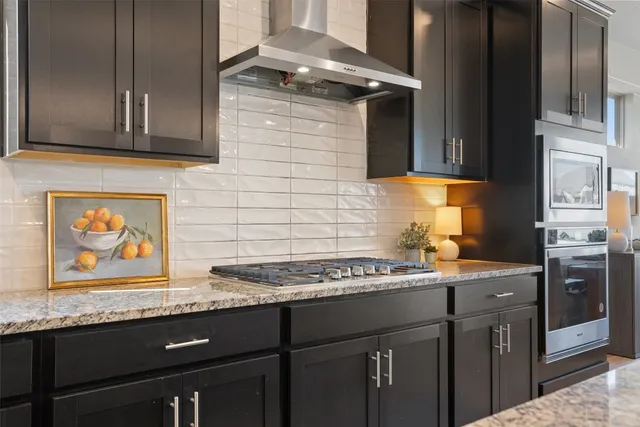 a kitchen with stainless steel appliances granite countertop a stove sink and cabinets