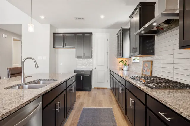 a kitchen with stainless steel appliances granite countertop a sink stove and cabinets