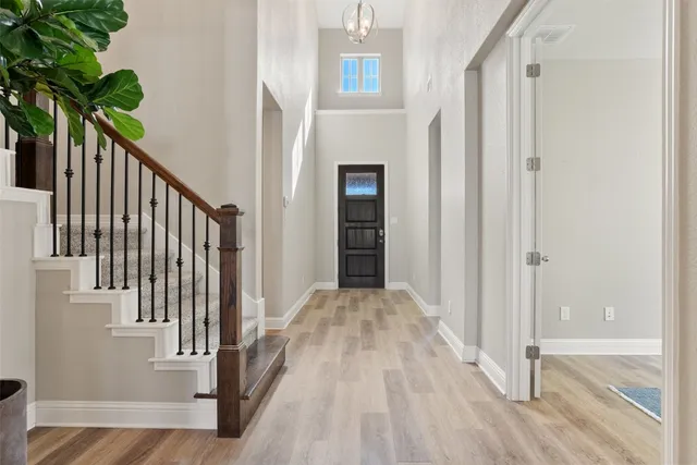 a view of a hallway with wooden floor and staircase