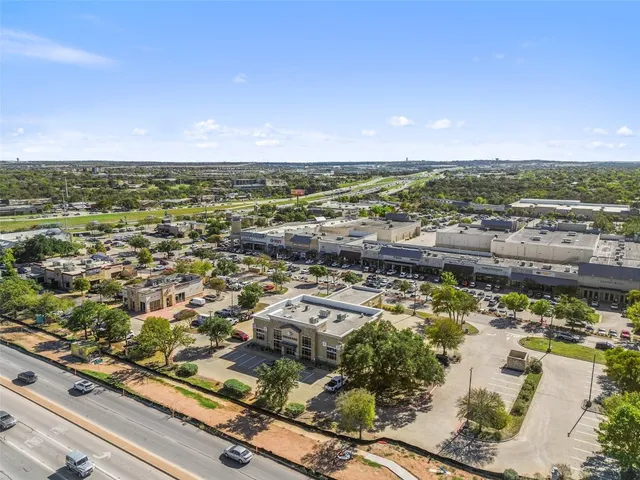 an aerial view of a houses with a yard and lake view