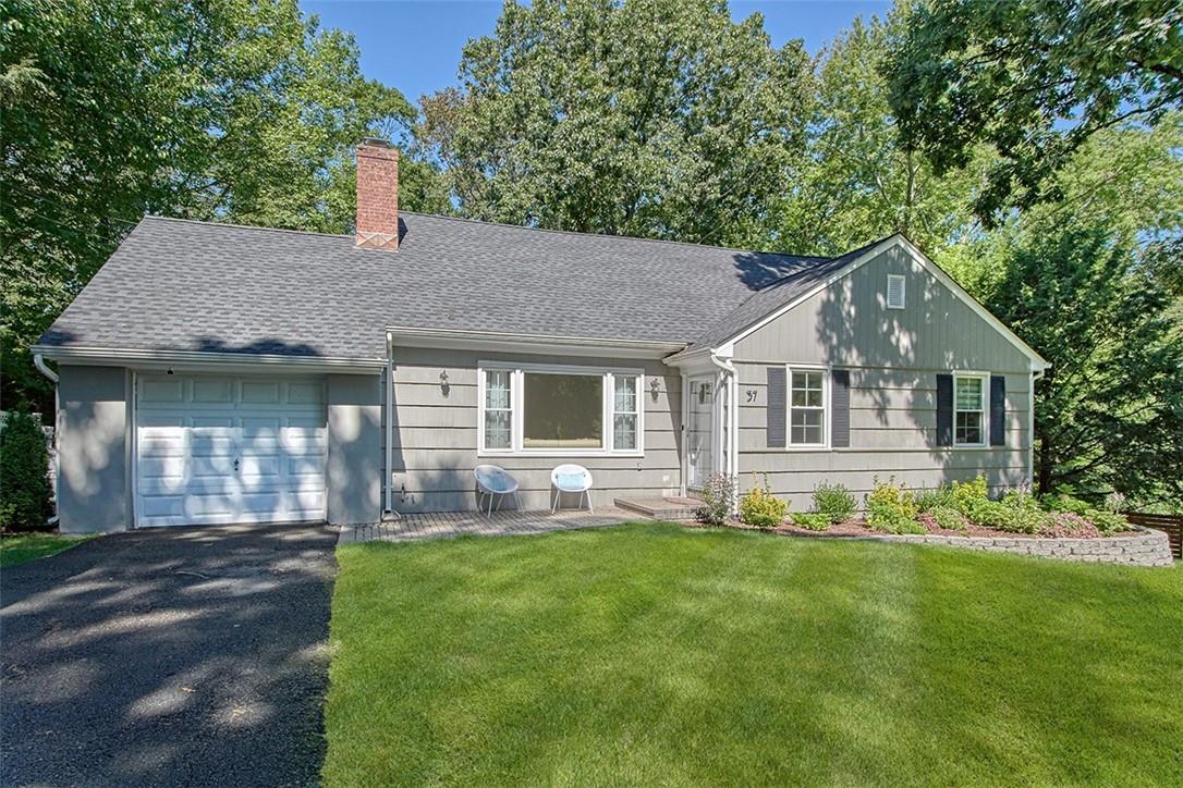a front view of a house with a garden and yard